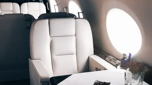 Cabina di un jet privato con tavolo apparecchiato