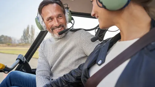 Passeggeri con cuffie a bordo di un elicottero