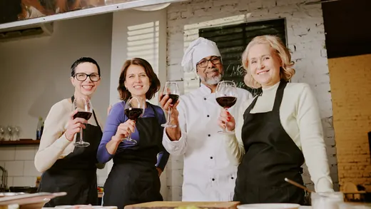 Partecipanti a una cooking class con un calice di rosso